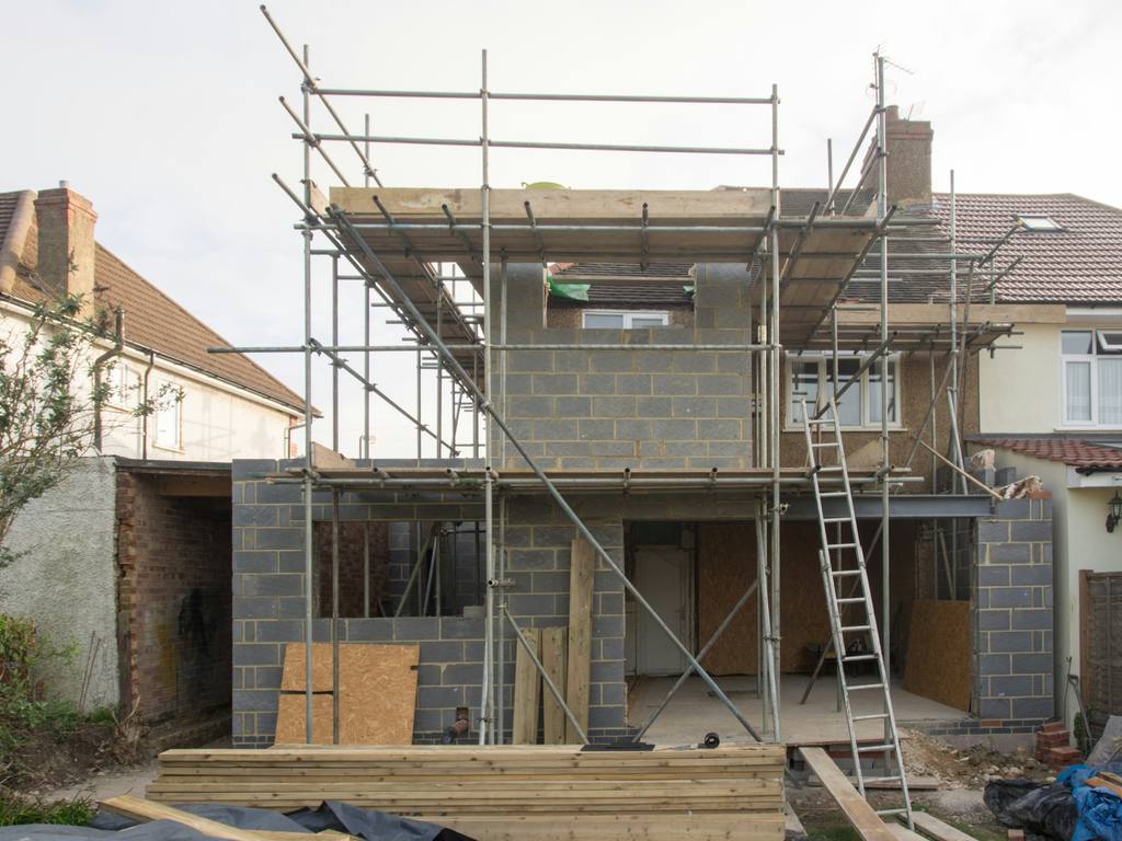 Residential scaffold access erected around a house during exterior works.
