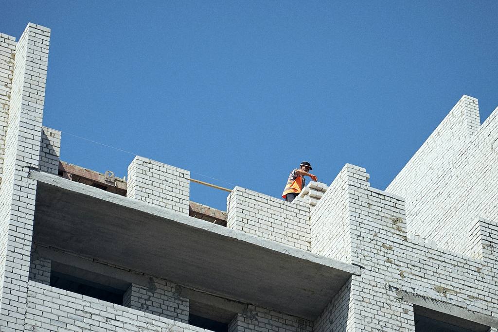 Exterior building works being carried out at height with scaffold access.